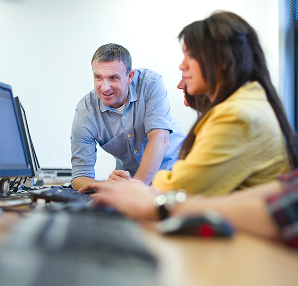 Male and two females looking at computer screens