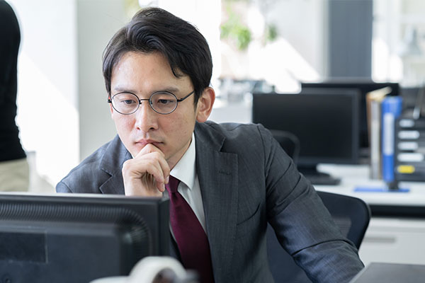 Male business man with glasses looking at computer screen