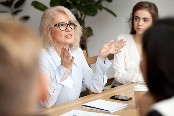 Two females and others at conference table