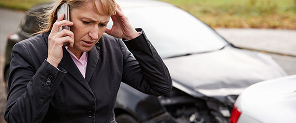 Female woman on phone outside after car accident