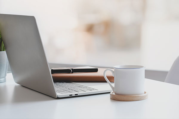 White laptop and coffee mug on desk