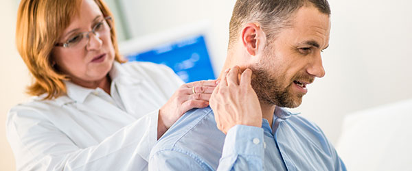 Female doctor touching neck of male patient