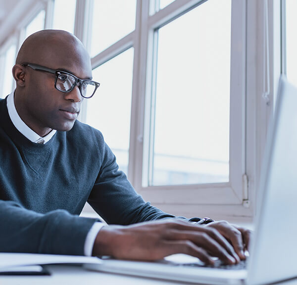 Male businessman in blue sweater typing on keyboard