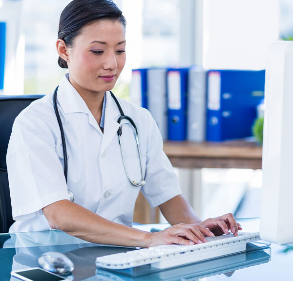 Female nurse or doctor typing on keyboard