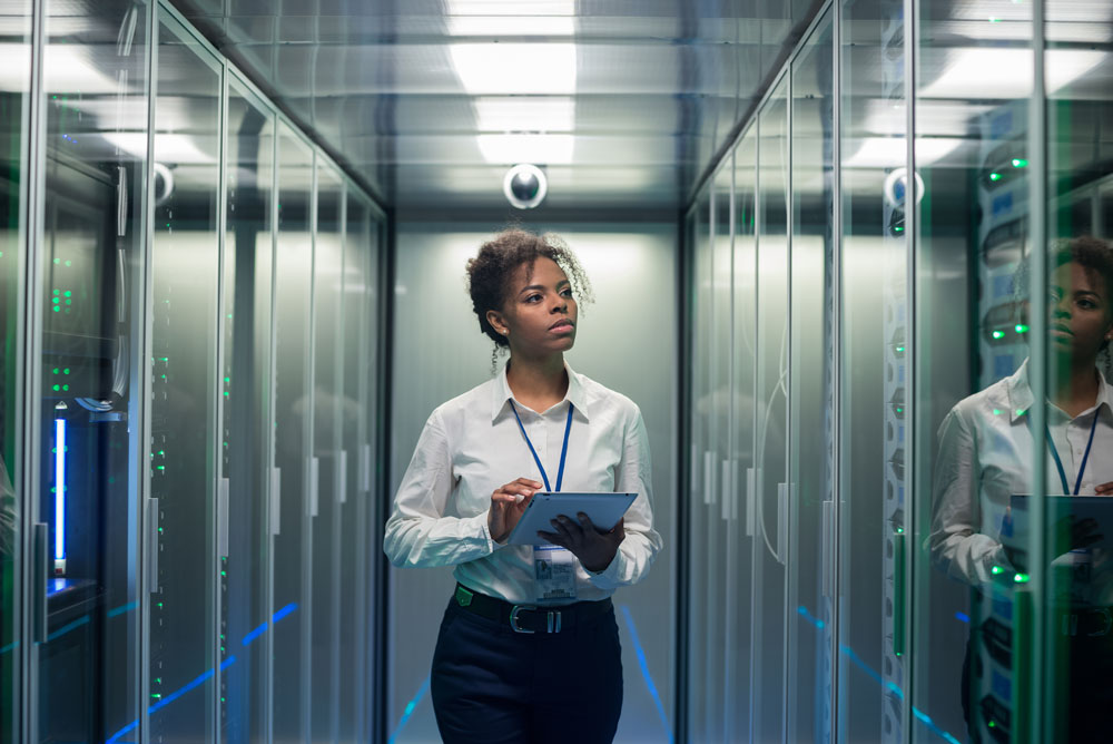 Business woman walking with clipboard in server room