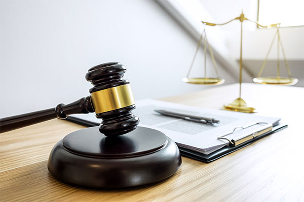 Gavel, scales and legal paperwork on a table