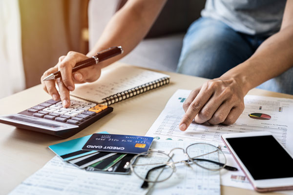 Pair of arms and hands with credit cards and bills on table as if someone is paying bills