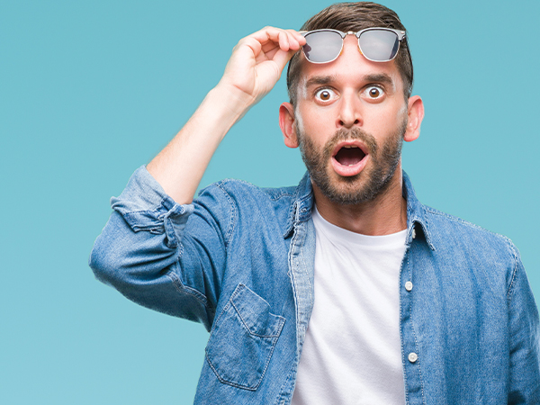 Man lifting glass with a surprised expression, looking at claim findings.